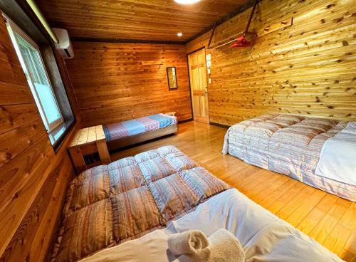 a bedroom with two beds in a log cabin at Ringo Lodge Hakuba in Hakuba