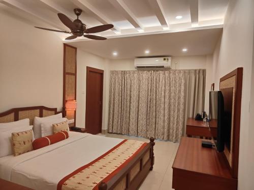 a bedroom with a bed and a ceiling fan at Mohor Kutir Resorts in Bolpur