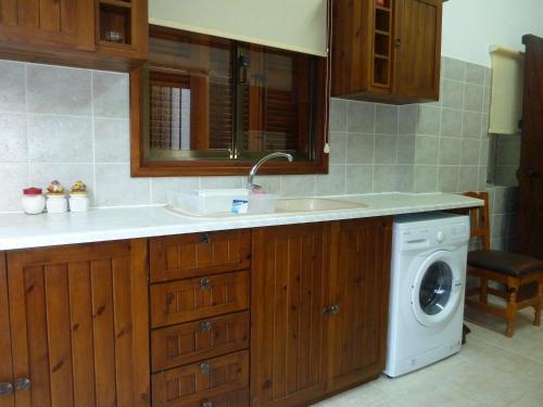 a kitchen with a sink and a washing machine at Hidden Garden in Kyrenia