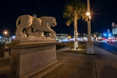 a statue of a lion on a sidewalk at night at Grandma's Rest East in Saint Augustine