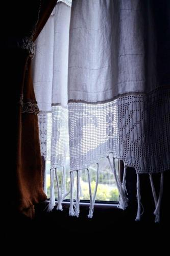 a window with a white curtain with a view at Sokak Boutique Hotel in Berat