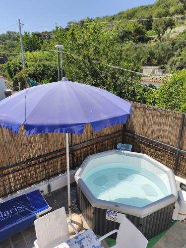 a blue umbrella sitting next to a hot tub at Casa VERDE MAREMONTI in Ischia