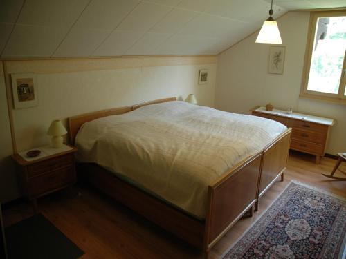 a bedroom with a bed and a dresser and a window at Charming Chalet Near Trails in Mörel