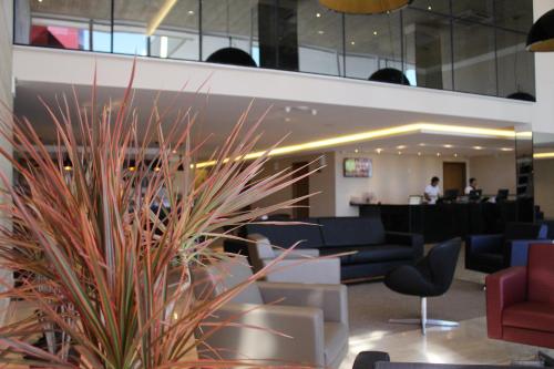 a lobby with a waiting area with blue and red furniture at Ibiza Plaza Hotel in Anápolis