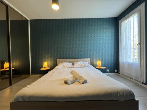 a bedroom with a bed with two towels on it at L'Olympia - Parking - Gazonfier - 4p - Rêve au Mans in Le Mans