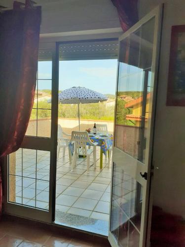 an open door to a patio with an umbrella at Lucy's Home in Carbonia
