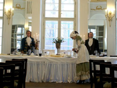 a woman is standing in front of a table at Pałac Bażantarnia in Pszczyna