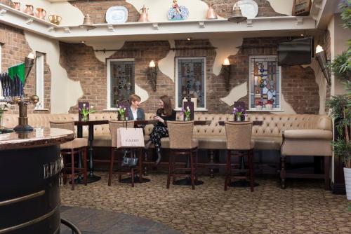 two women sitting at a table in a restaurant at Four Seasons Hotel & Leisure Club in Monaghan