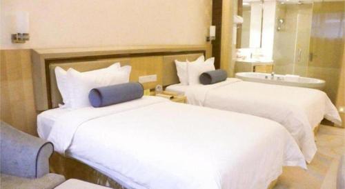 a hotel room with two beds and a sink at Shanghai Fuyue Hotel in Shanghai