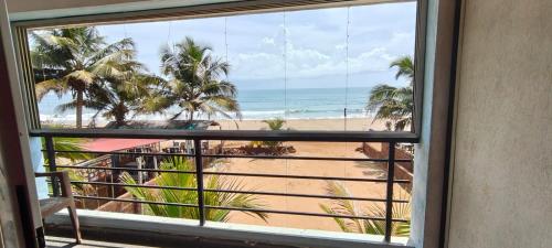 a view of the beach from a window at Gokarna Govekar Sea Facing Rooms in Gokarn
