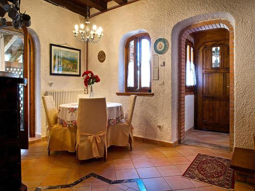 a room with a table and chairs and a door at Cottage in Italy with Alpine Fireplace in Ponte nellʼAlpi