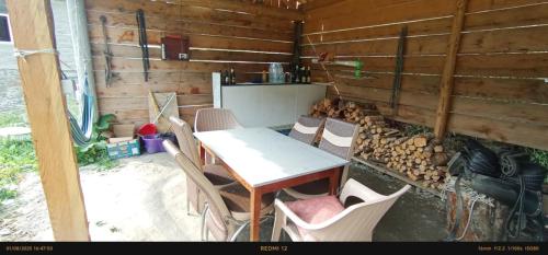a table and chairs in a room with a wooden wall at Guest house River side Adishi in Adishi