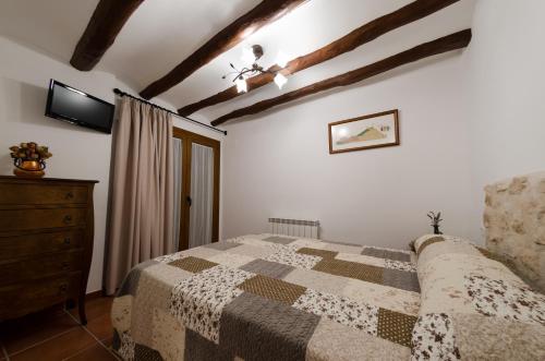 a bedroom with a bed and a dresser at Casa Rural El Solanar in Castelserás