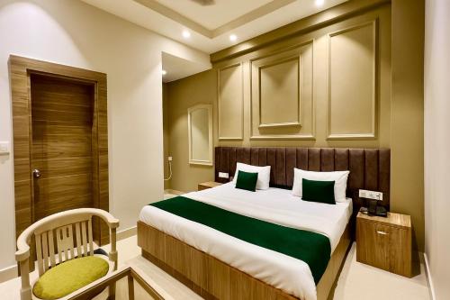 a bedroom with a large bed and a chair at Hotel Citi Continental in New Delhi