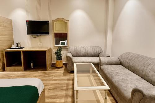 a living room with a couch and a tv at Hotel Citi Continental in New Delhi