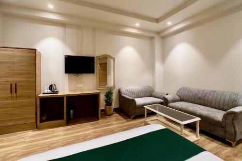a living room with a couch and a tv at Hotel Citi Continental in New Delhi