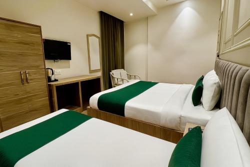 a hotel room with two beds and a television at Hotel Citi Continental in New Delhi