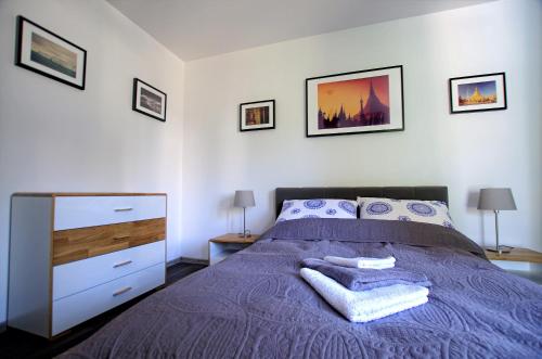 コウォブジェクにあるApartamenty Bryzaのベッドルーム(紫色のベッド1台、ドレッサー付)