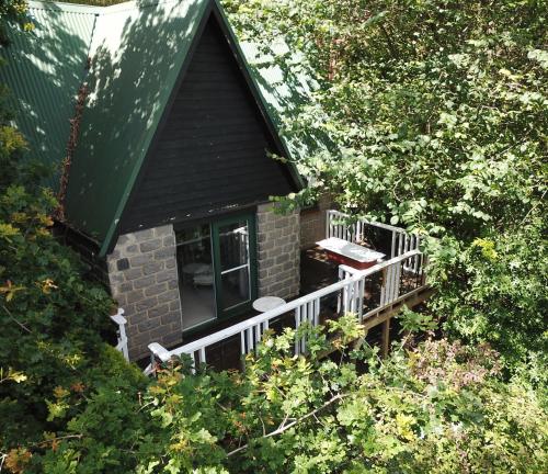 a small house with a balcony in the trees at The Cottage at Mirador Springs Retreat