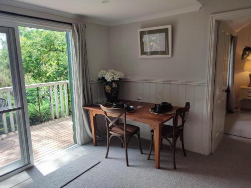 a dining room with a table and chairs and a balcony at The Cottage at Mirador Springs Retreat