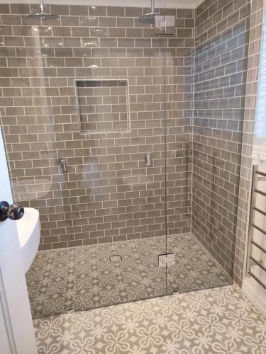 a shower with a glass door in a bathroom at The Cottage at Mirador Springs Retreat