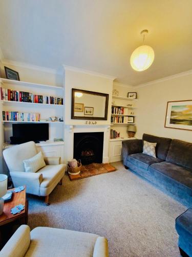 a living room with a couch and a fireplace at Hope Cottage - Charming 3 bedroom house, Southwold in Southwold