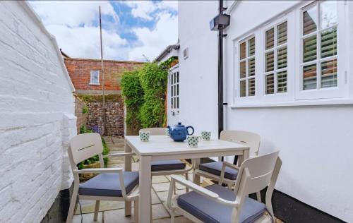 ein weißer Tisch und Stühle auf einer Terrasse in der Unterkunft Hope Cottage - Charming 3 bedroom house, Southwold in Southwold