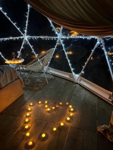 a tent with a table and lights on the floor at Mtirala Yurt in Batumi