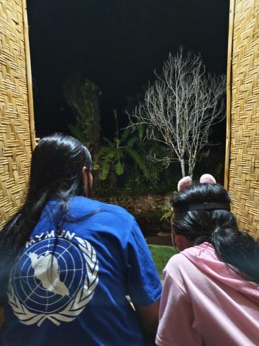 two women looking at a tree in a window at Tranquil Riverside Camping in Ambengan