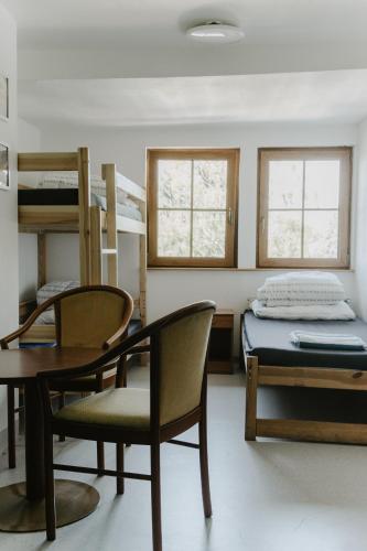 a room with a table and chairs and a bunk bed at Schronisko PTTK Pod Muflonem in Duszniki Zdrój