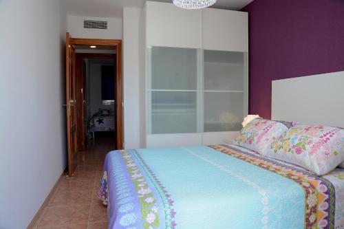 a bedroom with a bed with a purple wall at Brisa Beach in Santa Susanna