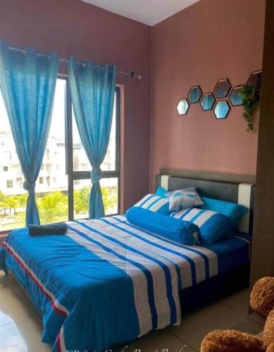 a bedroom with a blue bed with a window at Pool & Sea View Casa Azalea at Swiss Garden Resort Residence - 2 bedroom apartment in Kuantan