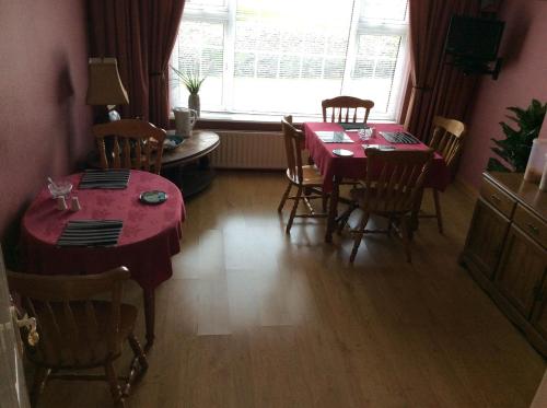 a dining room with two tables and chairs and a window at Riverside House in Roscommon