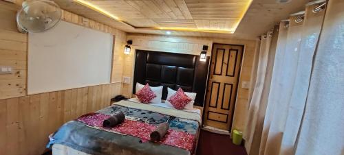 a bedroom with a bed in a room with a screen at The K2 Alpine in Pahalgām