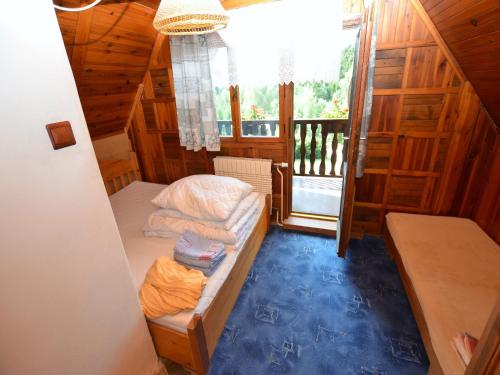 a small bedroom with a bed and a balcony at Family Chalet in Giant Mountains in Mrklov