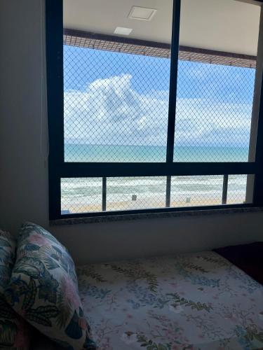 a bedroom with a window with a bed and a pillow at Frente a Mar na Praia dos Milionários in Ilhéus
