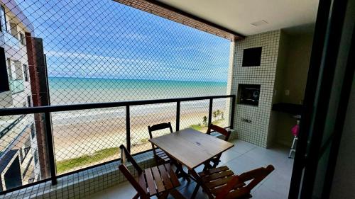 a balcony with a table and chairs and a view of the beach at Frente a Mar na Praia dos Milionários in Ilhéus
