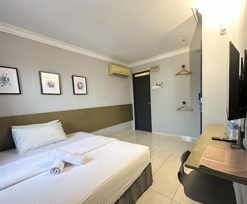 une chambre avec un lit, un bureau et une télévision dans l'établissement # Hashtag Hotel - Self Check in, à Alor Setar