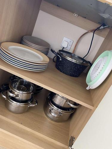 a shelf with plates and pots and pans at Havana De Luxe Bredene in Bredene