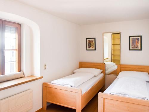 two beds in a room with two windows at Apartment in Brixlegg near Ski Juwel Slopes in Rattenberg