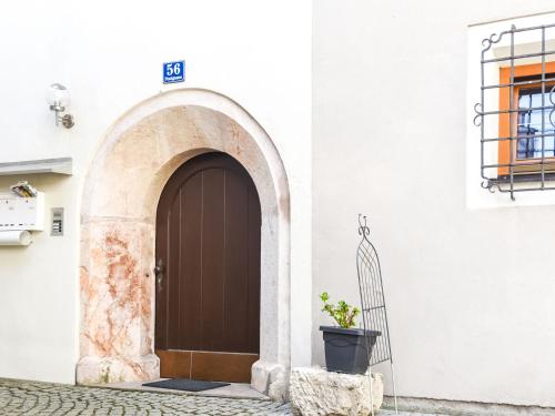 a brown door on a white building with a potted plant at Apartment in Brixlegg near Ski Juwel Slopes in Rattenberg
