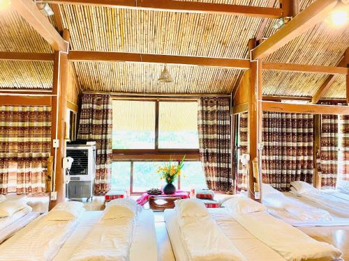 a large room with several beds and a window at Moc Chau Retreat in Mộc Châu