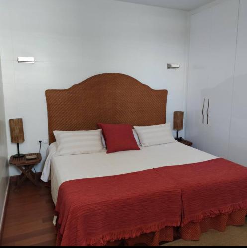 a bedroom with a large bed with a wooden headboard at Casa Vento in La Asomada
