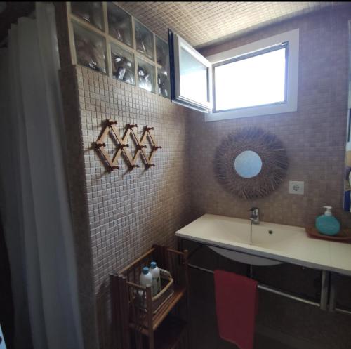 a bathroom with a sink and a mirror and a window at Casa Vento in La Asomada