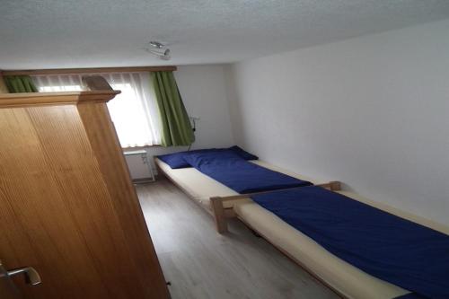 a bedroom with a bed with blue sheets and a window at Chalet in Lenk near Simmen Falls in Lenk