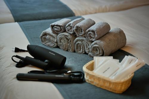a hair dryer and a basket of towels on a bed at Otter Stay - Kogane in Nagoya
