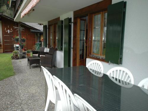a black table and white chairs on a patio at Chalet in Lenk near Simmen Falls in Lenk