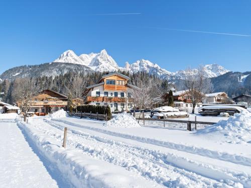 a street covered in snow with mountains in the background at Apartment in Saalfelden near Ski Slopes in Saalfelden am Steinernen Meer