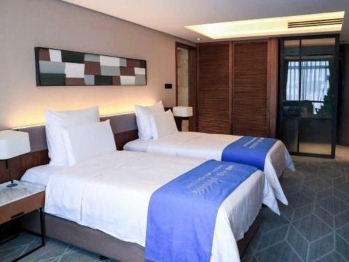 a hotel room with two beds in a room at Chongqing The Lotus Hotel in Chongqing