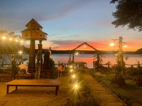 a bench in front of a lake at sunset at Biển Hồ Garden Glamping in Bien Ho
